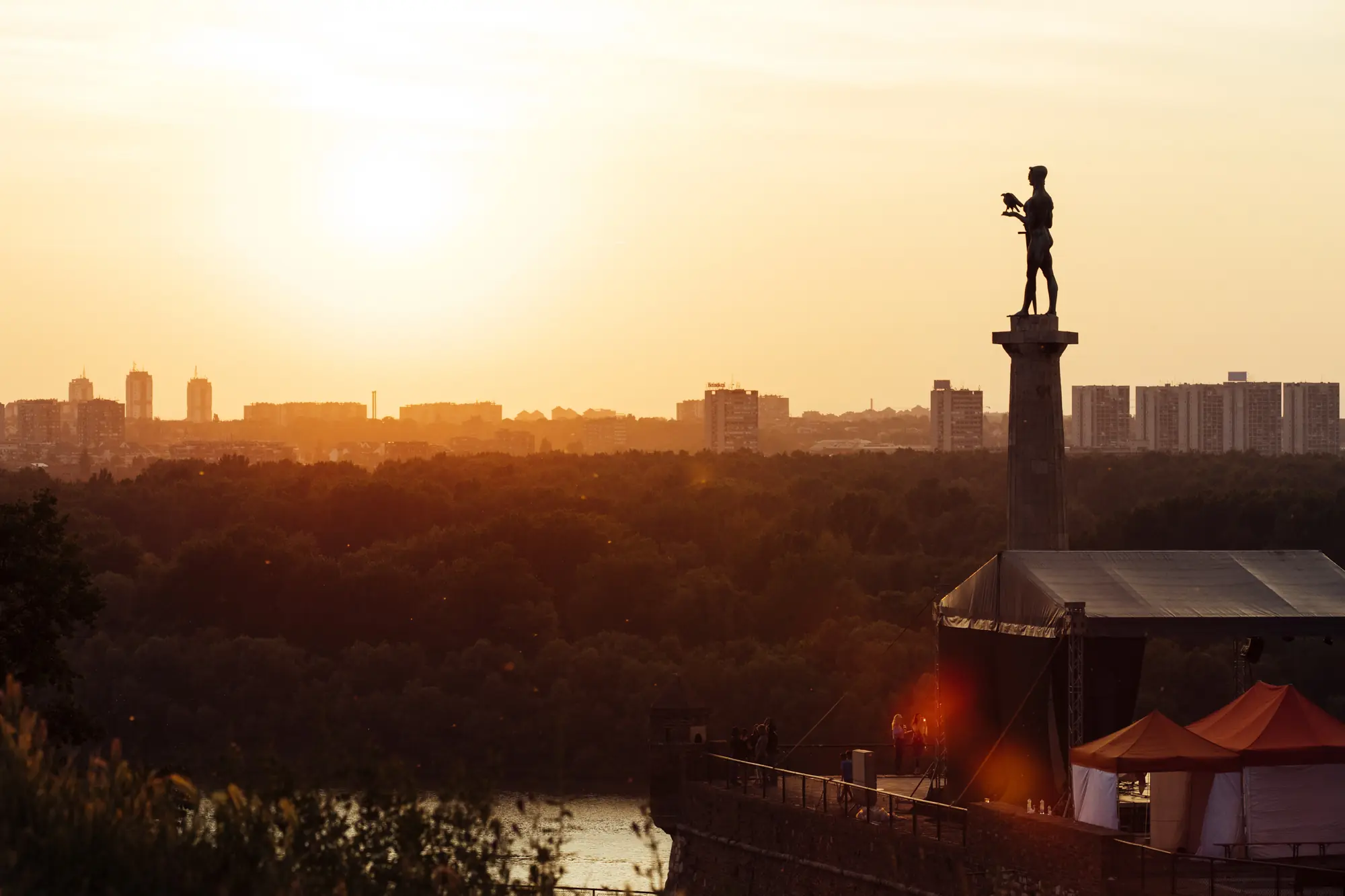 Pobednik on Kalemegdan at sunset, the Novi Beograd skyline behind